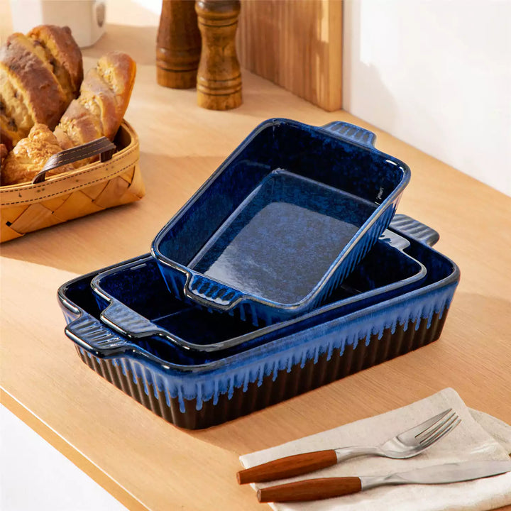 Starry blue stoneware baking dish set of 3 nested large medium small with ridged sides beside plate of fresh bread.
