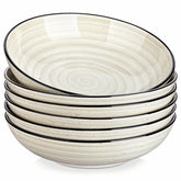 Bonbon double-sided stoneware pasta bowls in beige - artfully filled with pasta - fresh fruit salad - pumpkin soup - and oatmeal - exuding rustic charm on a white dining table