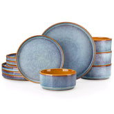A rustic breakfast spread featuring a plate of meat with vegetables - waffles topped with fruit - and assorted pastries on a white table - complemented by blue stoneware dinnerware