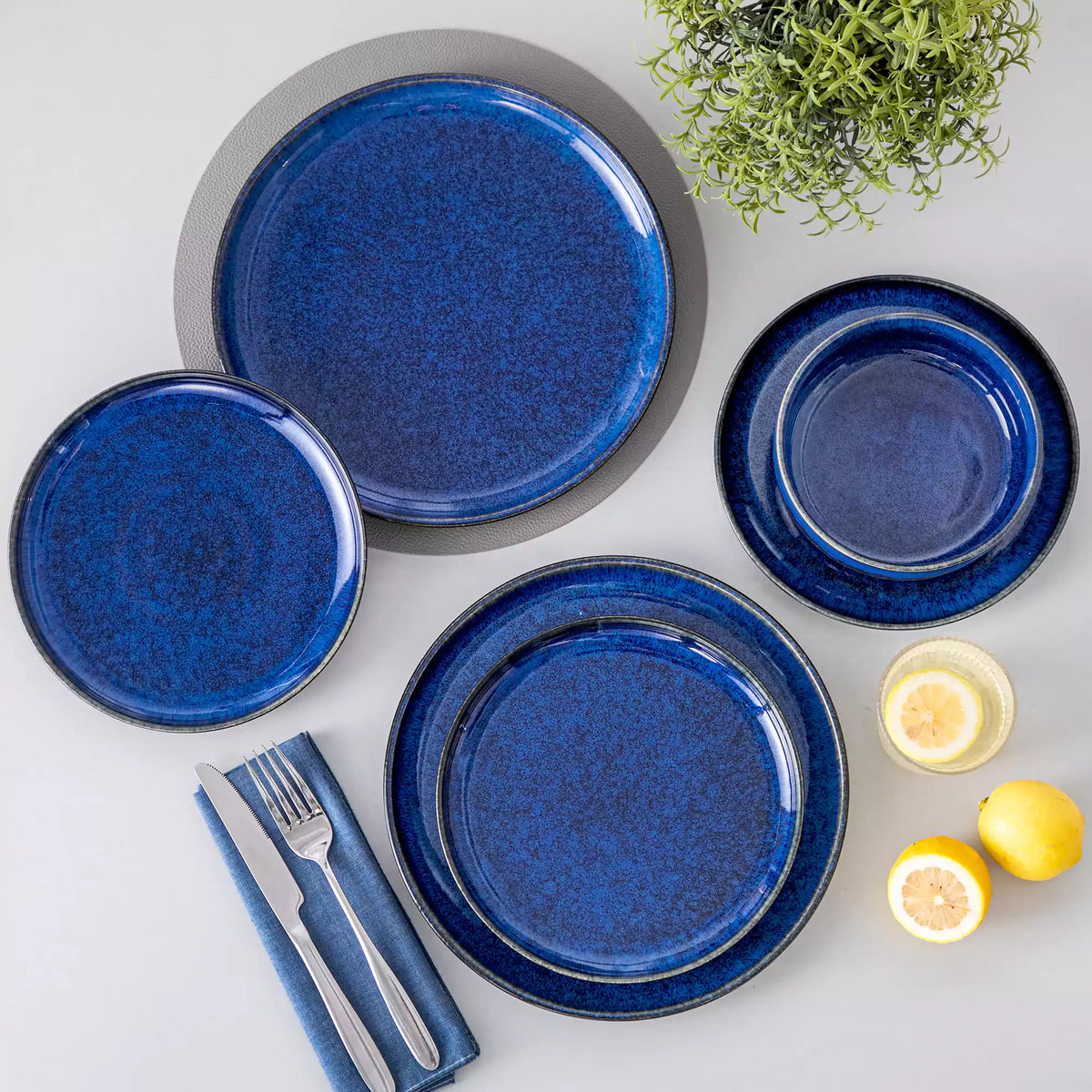 Starry Lipped-Edge 12 Piece Dinnerware Set in deep blue, empty plates styled on a table with lemon accents