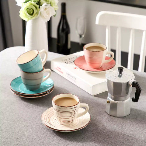 Steaming coffee served in colorful spiral stoneware cups and saucers-handmade vintage design - A