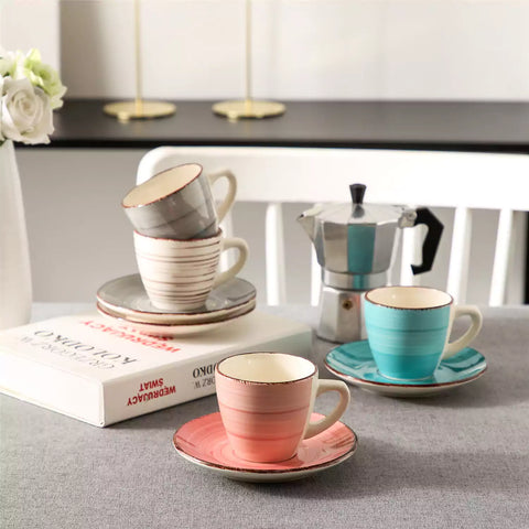 Steaming coffee served in colorful spiral stoneware cups and saucers-handmade vintage design - A