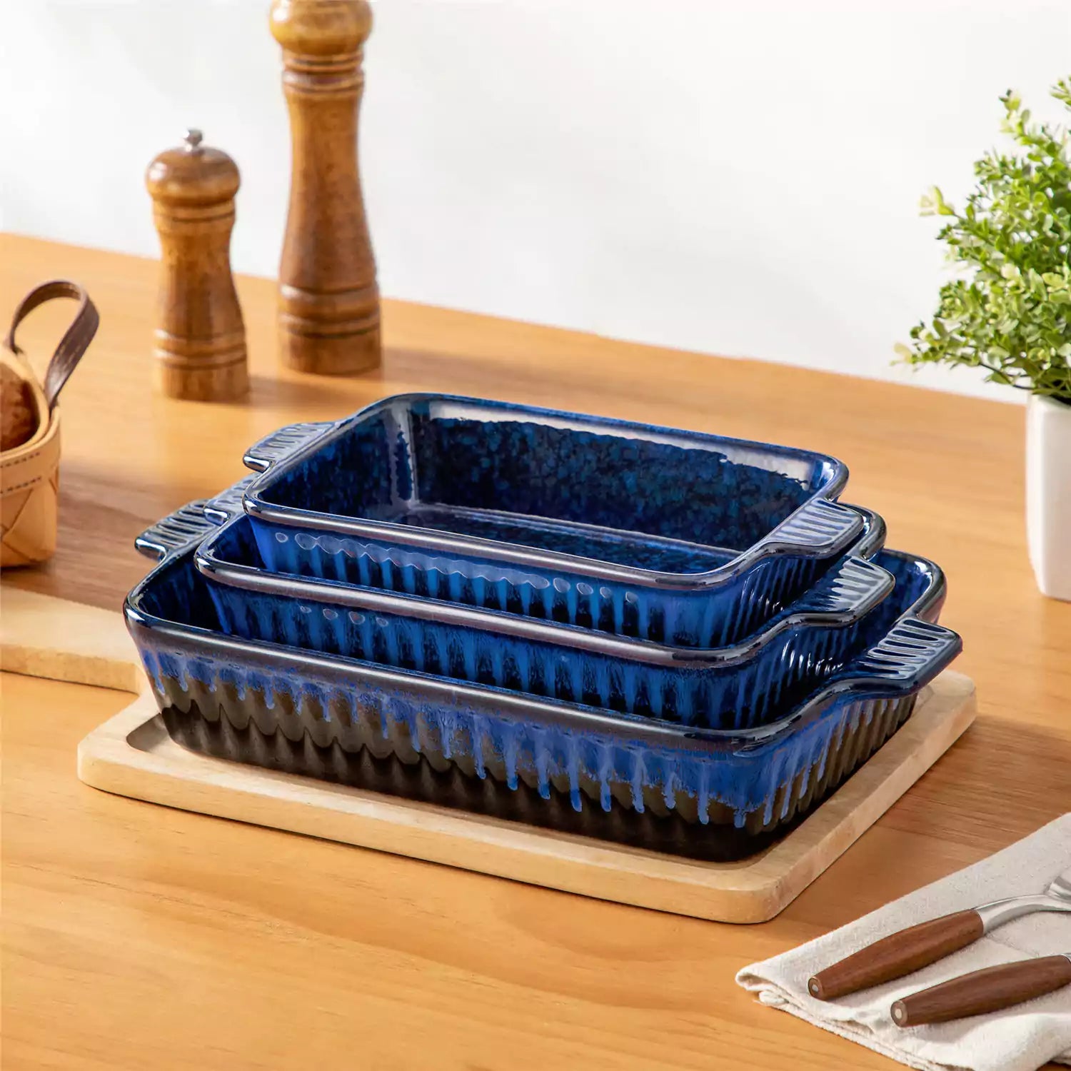 Starry 3 piece stoneware bakeware set with reactive glaze in navy blue on a wooden table