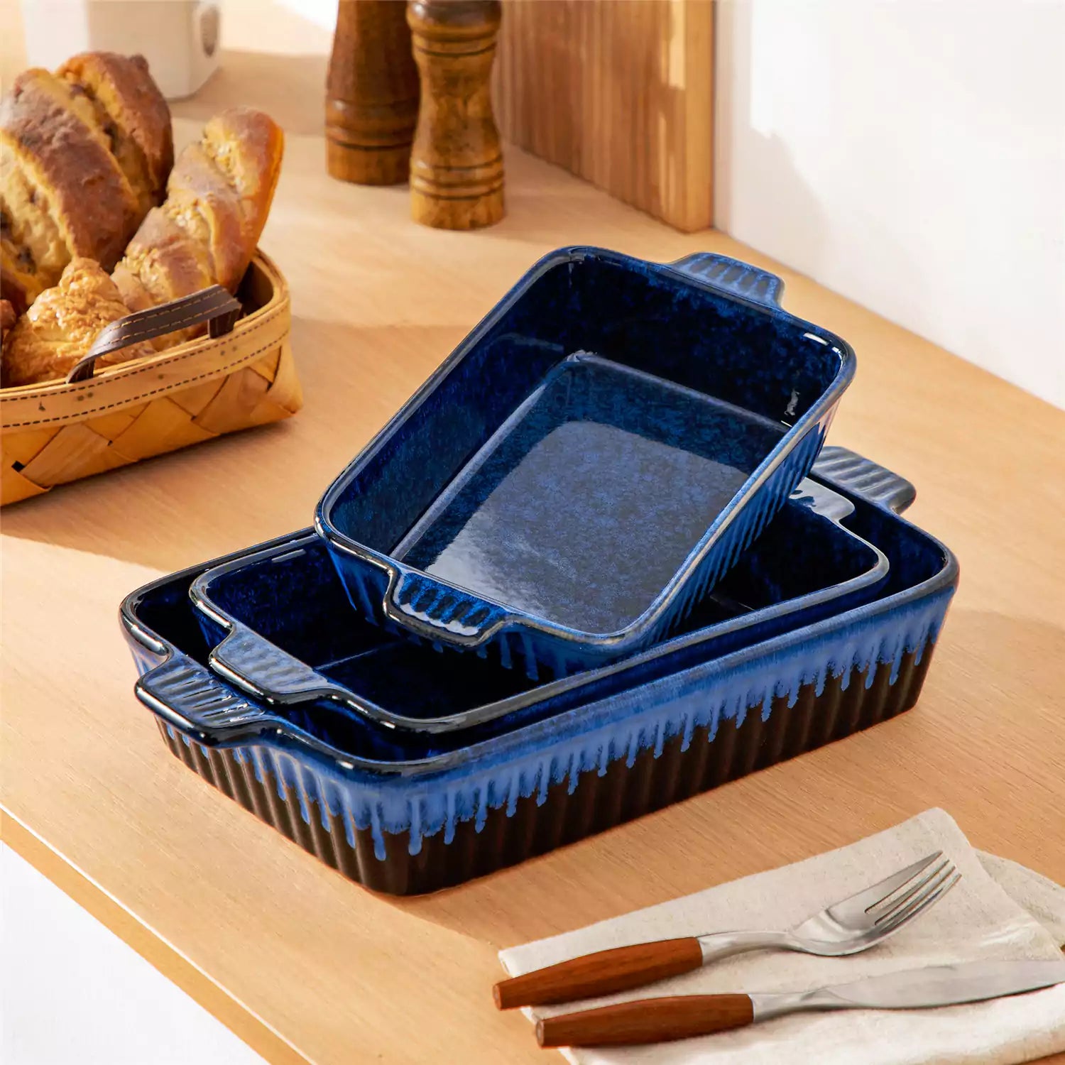 Starry 3 piece stoneware bakeware set with reactive glaze in navy blue on a wooden table