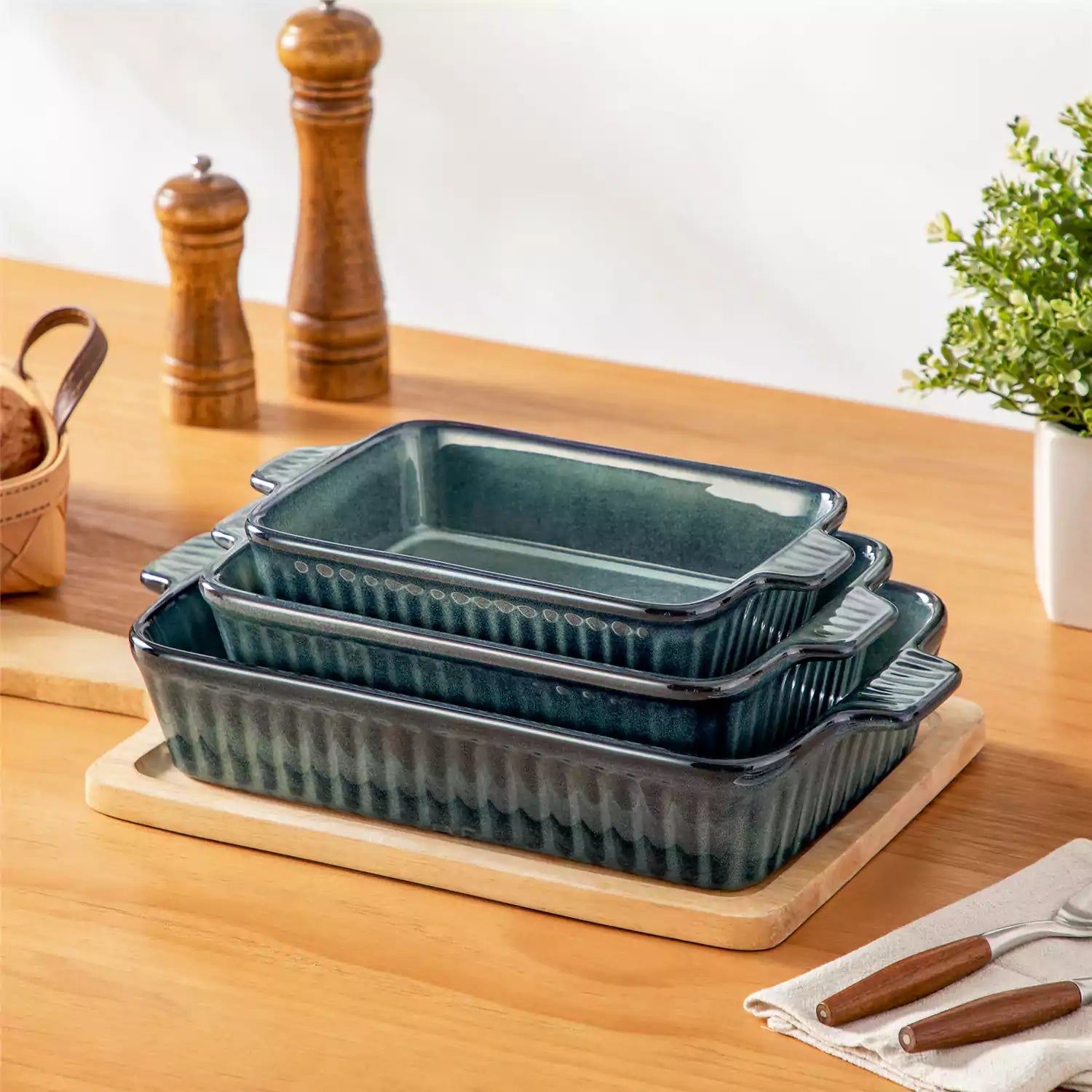 Starry 3 piece stoneware bakeware set with reactive glaze in green on a wooden table