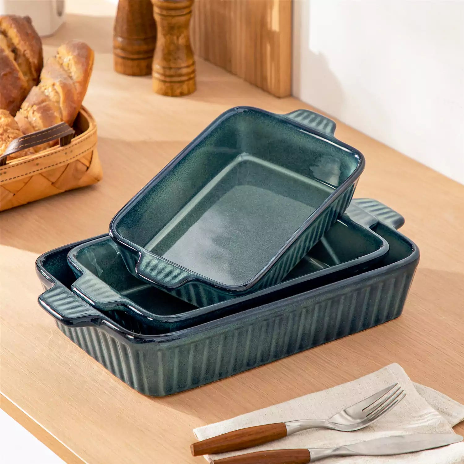 Starry 3 piece stoneware bakeware set with reactive glaze in green on a wooden table