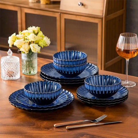 Blue reactive glaze stoneware bowls and plates from the Adonis 12 piece set with brown placemats and fresh flowers