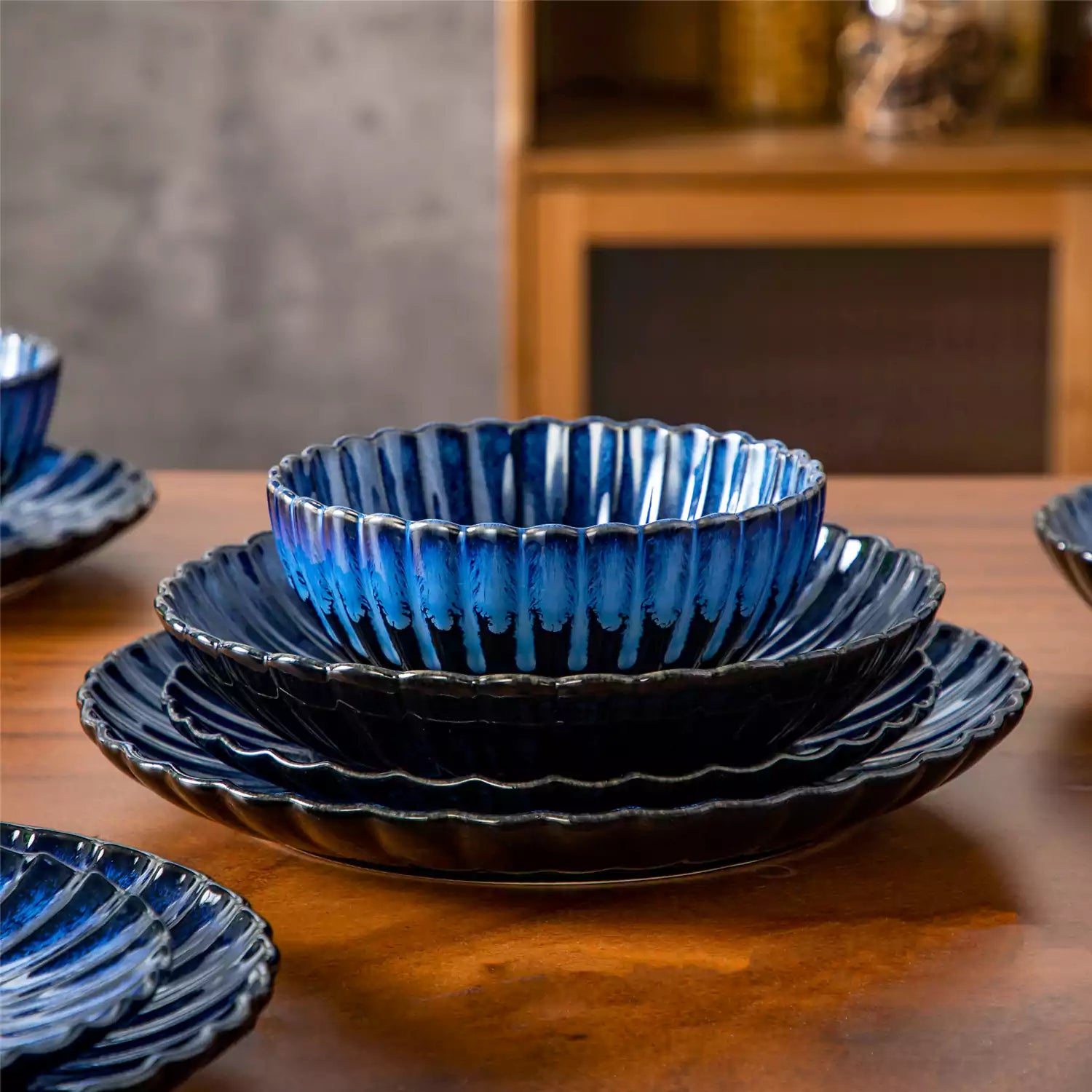 Farmhouse dining table set with Adonis teal blue reactive glaze stoneware plates woven placemats and wooden chairs