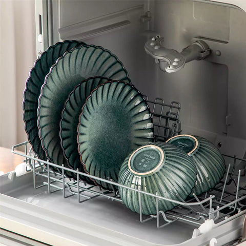 Adonis 18 piece reactive glaze dinnerware set in teal green with ribbed bowls and plates on a dining table