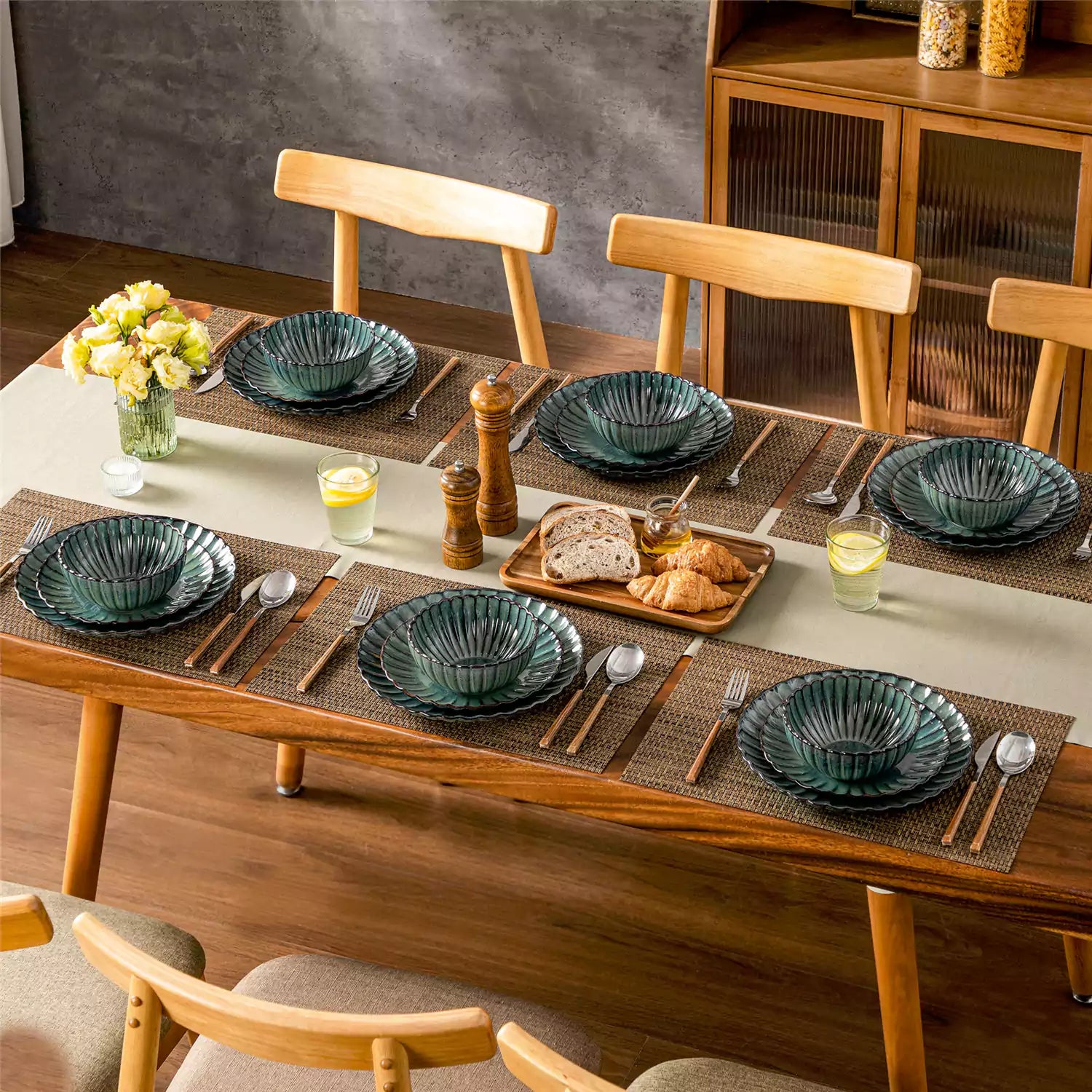 Adonis 18 piece reactive glaze dinnerware set in teal green with ribbed bowls and plates on a dining table