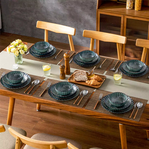 Farmhouse dining table set with Adonis teal green reactive glaze stoneware plates woven placemats and wooden chairs