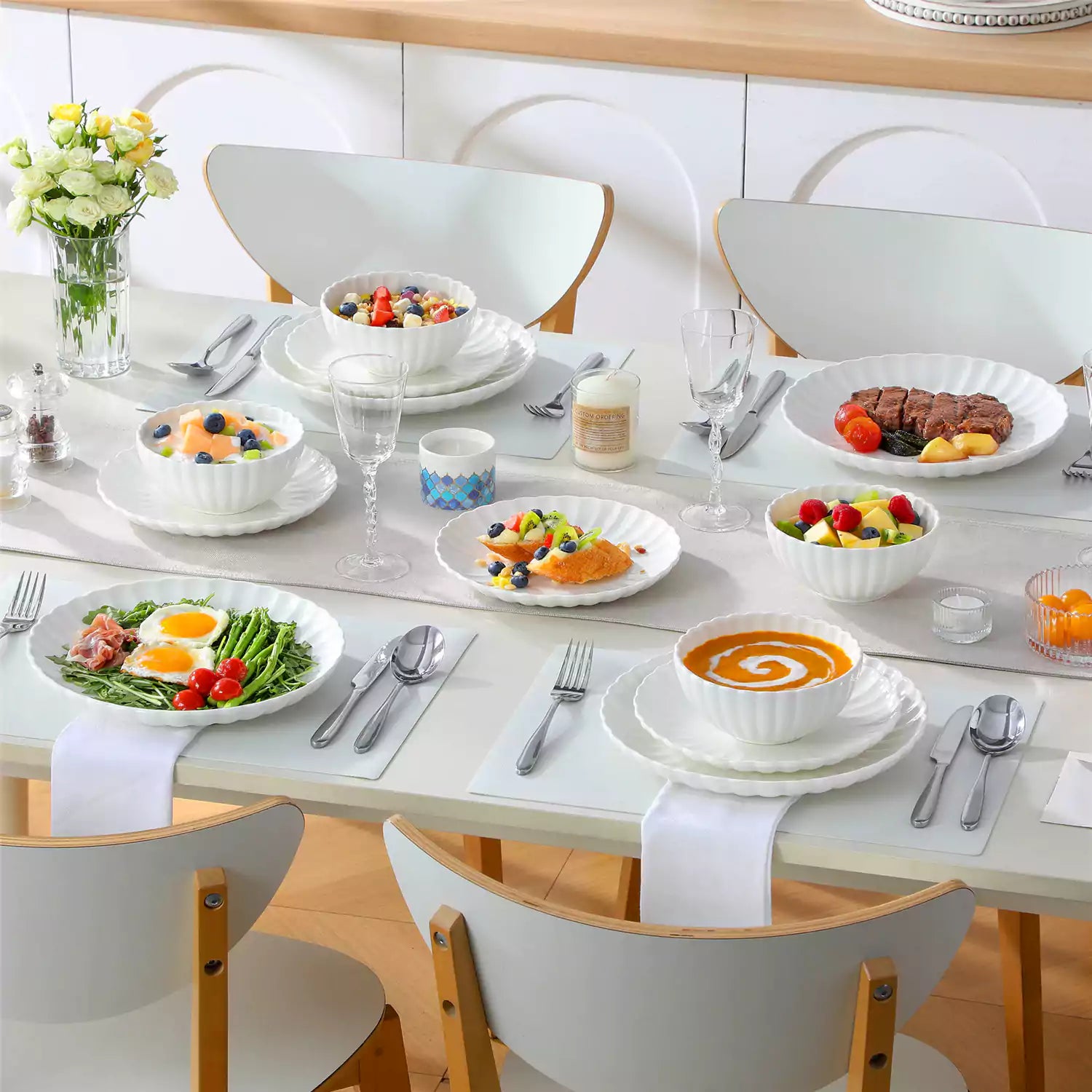 Bright modern dining room with Adonis white porcelain plates bowls white chairs and light wood accents