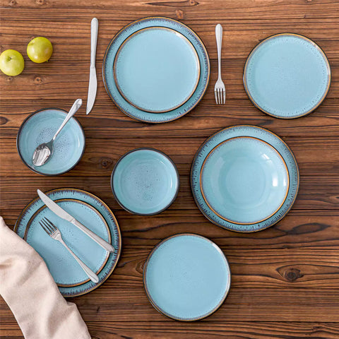 Assorted dishes with soup - dessert - and fruit salad on rustic wooden table - Amber 16-Piece blue stoneware dinnerware set with plates and bowls by vancasso
