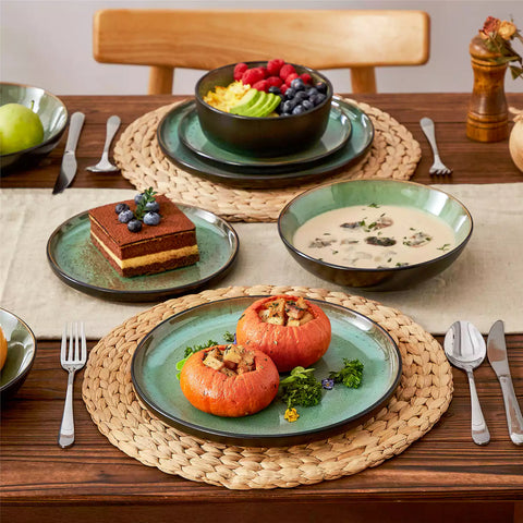 Assorted dishes with soup - dessert - and fruit salad on rustic wooden table - Amber 16-Piece green stoneware dinnerware set with plates and bowls by vancasso