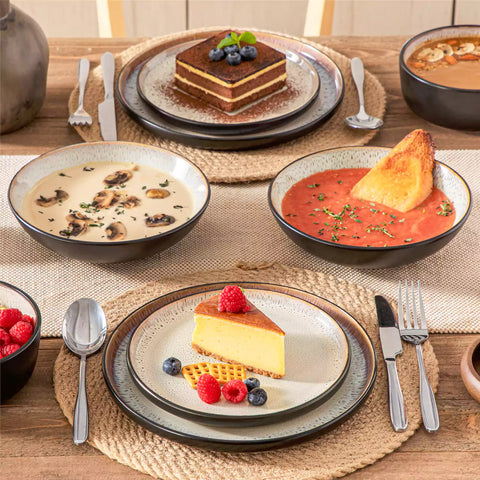 Assorted dishes with soup - dessert - and fruit salad on rustic wooden table - Amber 16-Piece beige stoneware dinnerware set with plates and bowls by vancasso
