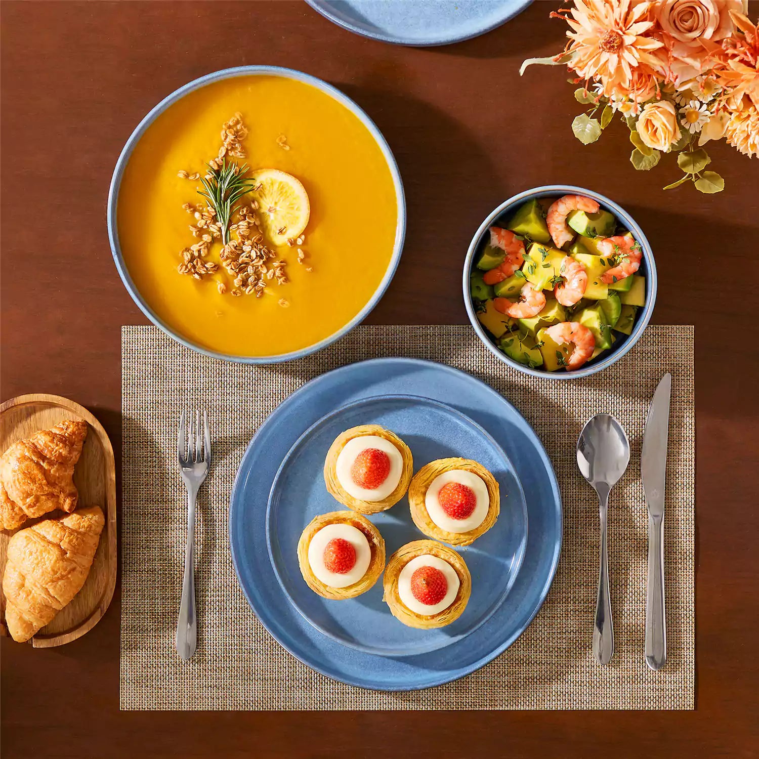 Anya 16 piece straight edge stoneware dinner set in blue with pasta soup and pastries on a modern farmhouse table