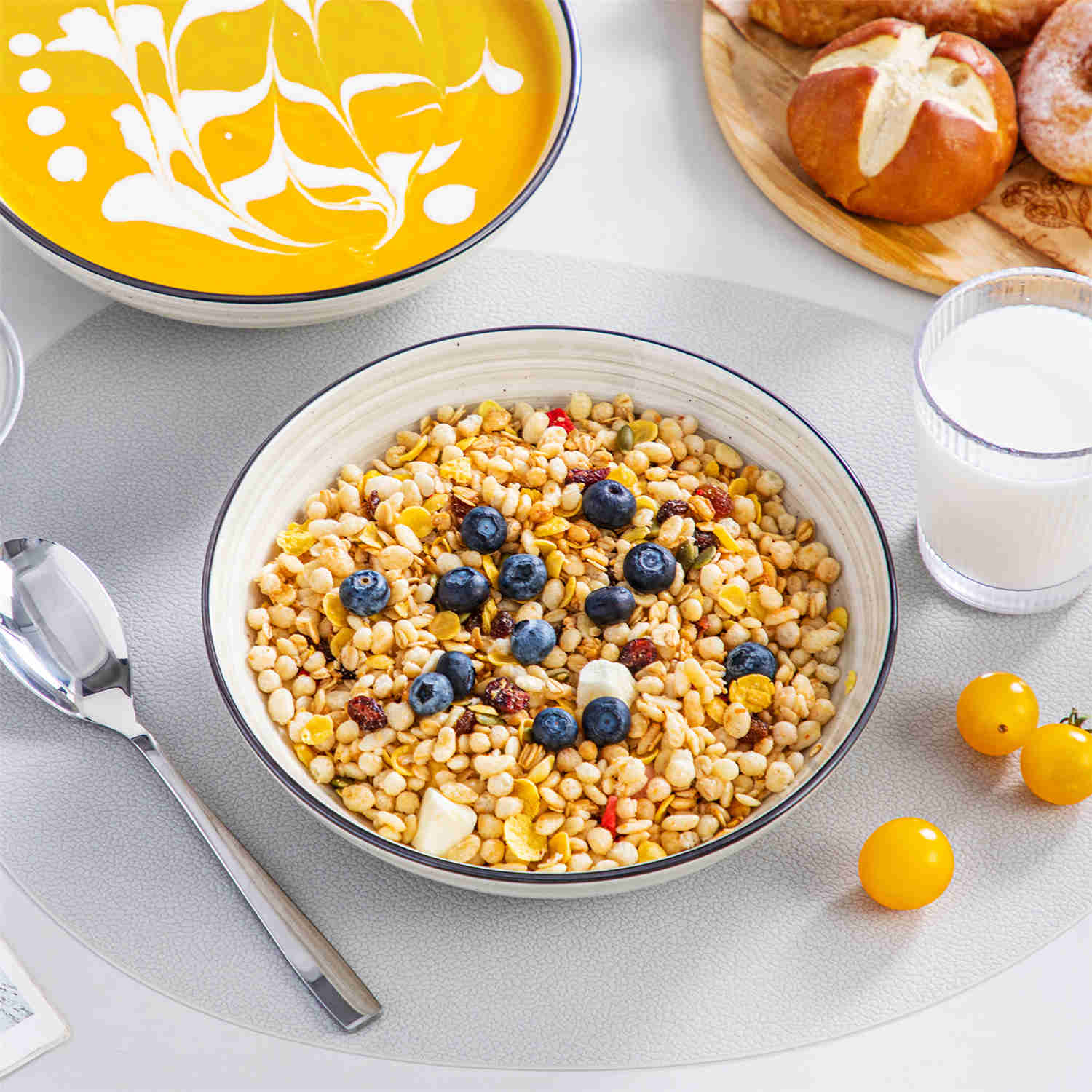 Bonbon double-sided stoneware pasta bowls in beige - artfully filled with pasta - fresh fruit salad - pumpkin soup - and oatmeal - exuding rustic charm on a white dining table