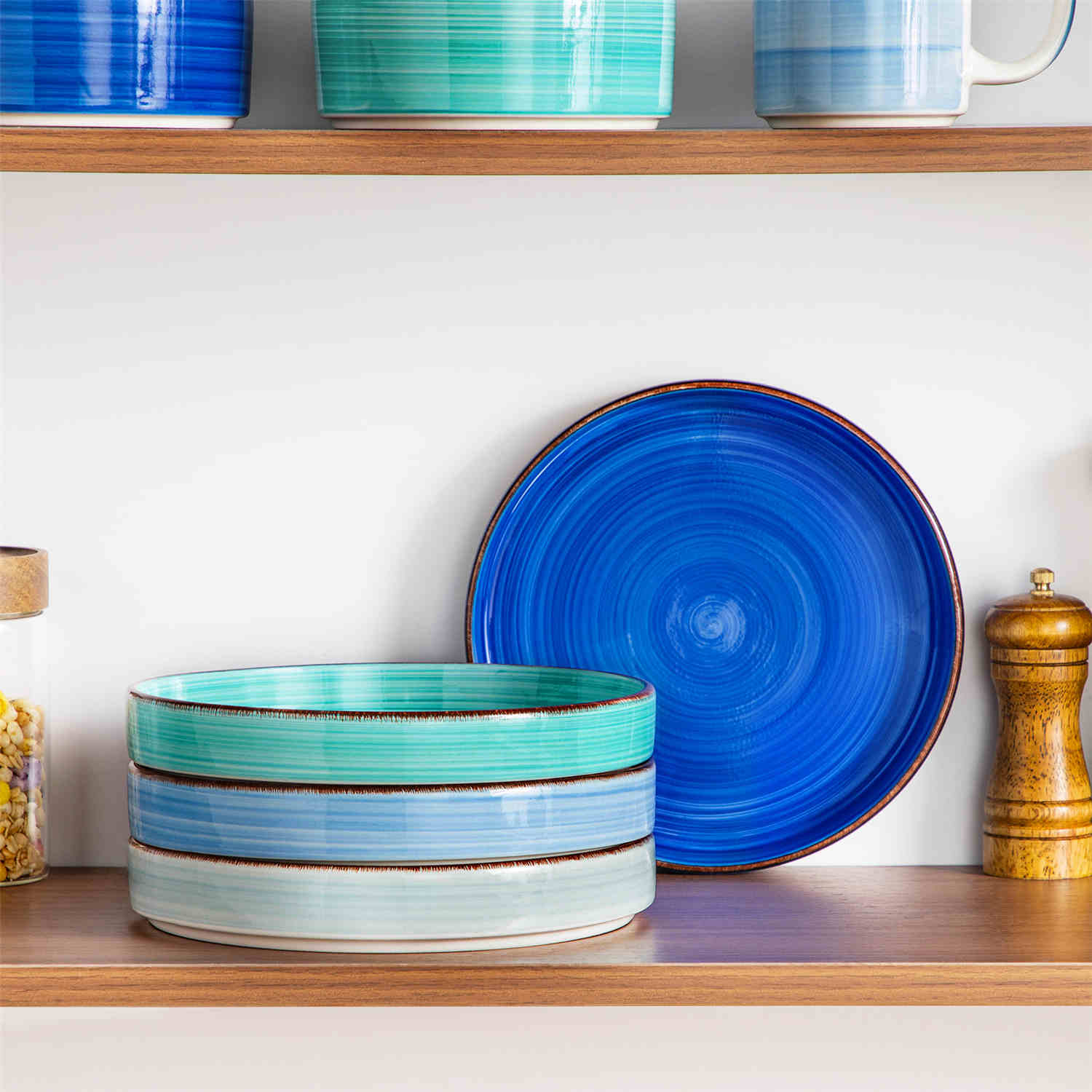 Bonita straight-edge pasta bowls set of 4 on a white table - filled with spaghetti - fruit salad - and mango - accompanied by a small honey jar - ibrant stoneware in ocean blues