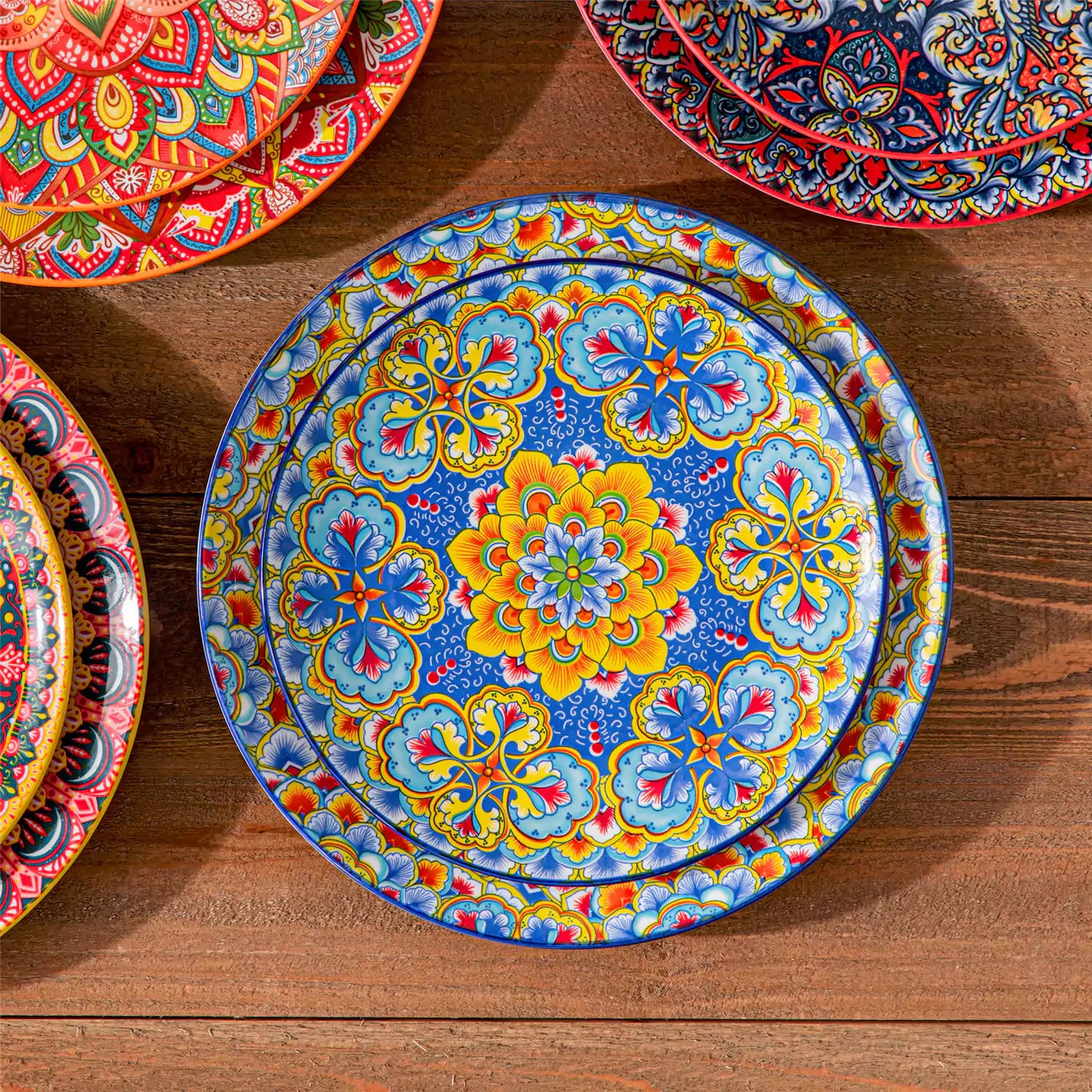 Bohemian Lumi 16 piece porcelain dinnerware set with colorful patterned plates and diamond-embossed bowls on a wooden table with assorted food and cutlery