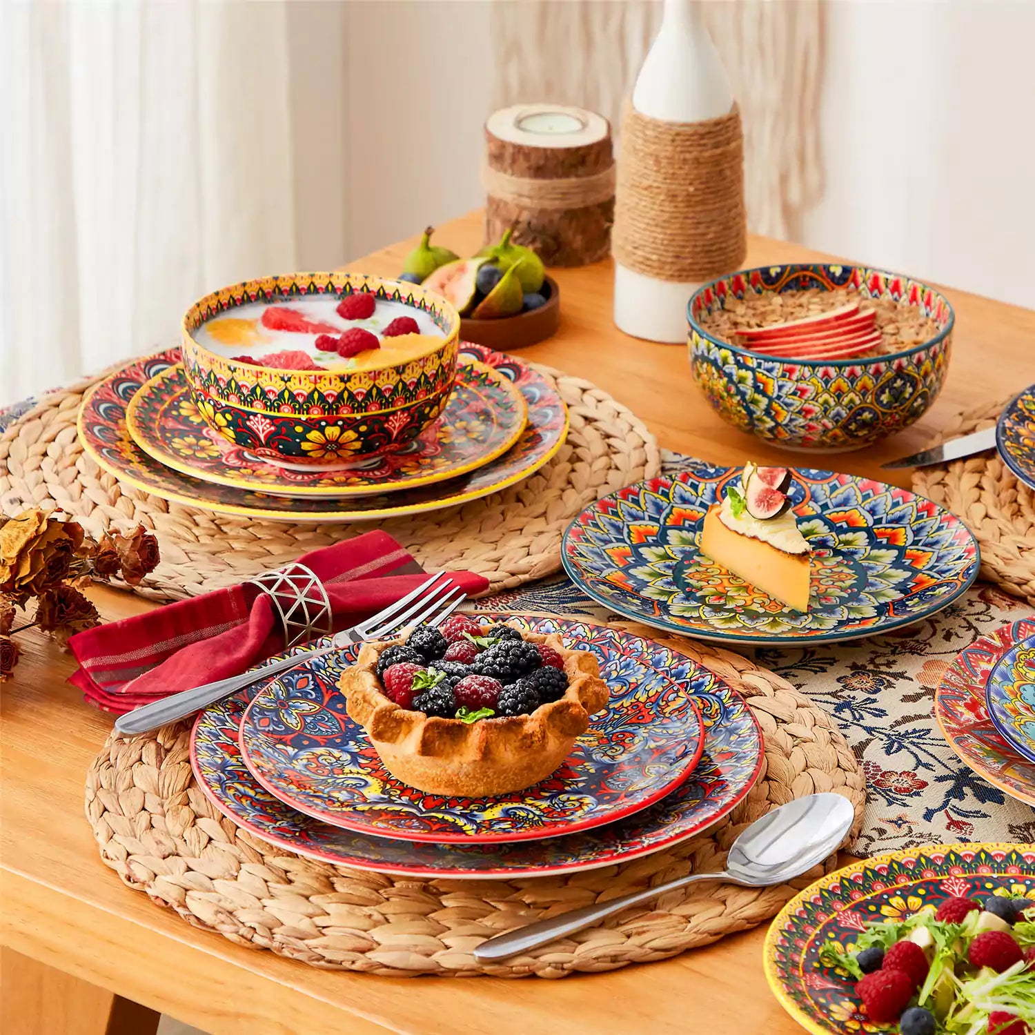 Lumi 18-piece Bohemian dinnerware set for six on a wooden table with colorful plates bowls and silverware in a playful Boho style