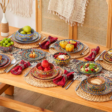 Lumi 18-piece Bohemian dinnerware set for six on a wooden table with colorful plates bowls and silverware in a playful Boho style