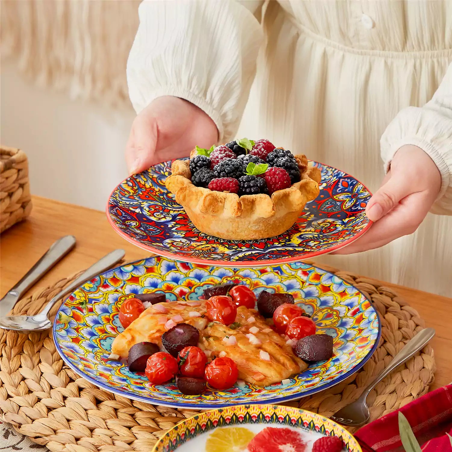 Lumi 18-piece Bohemian dinnerware set for six on a wooden table with colorful plates bowls and silverware in a playful Boho style