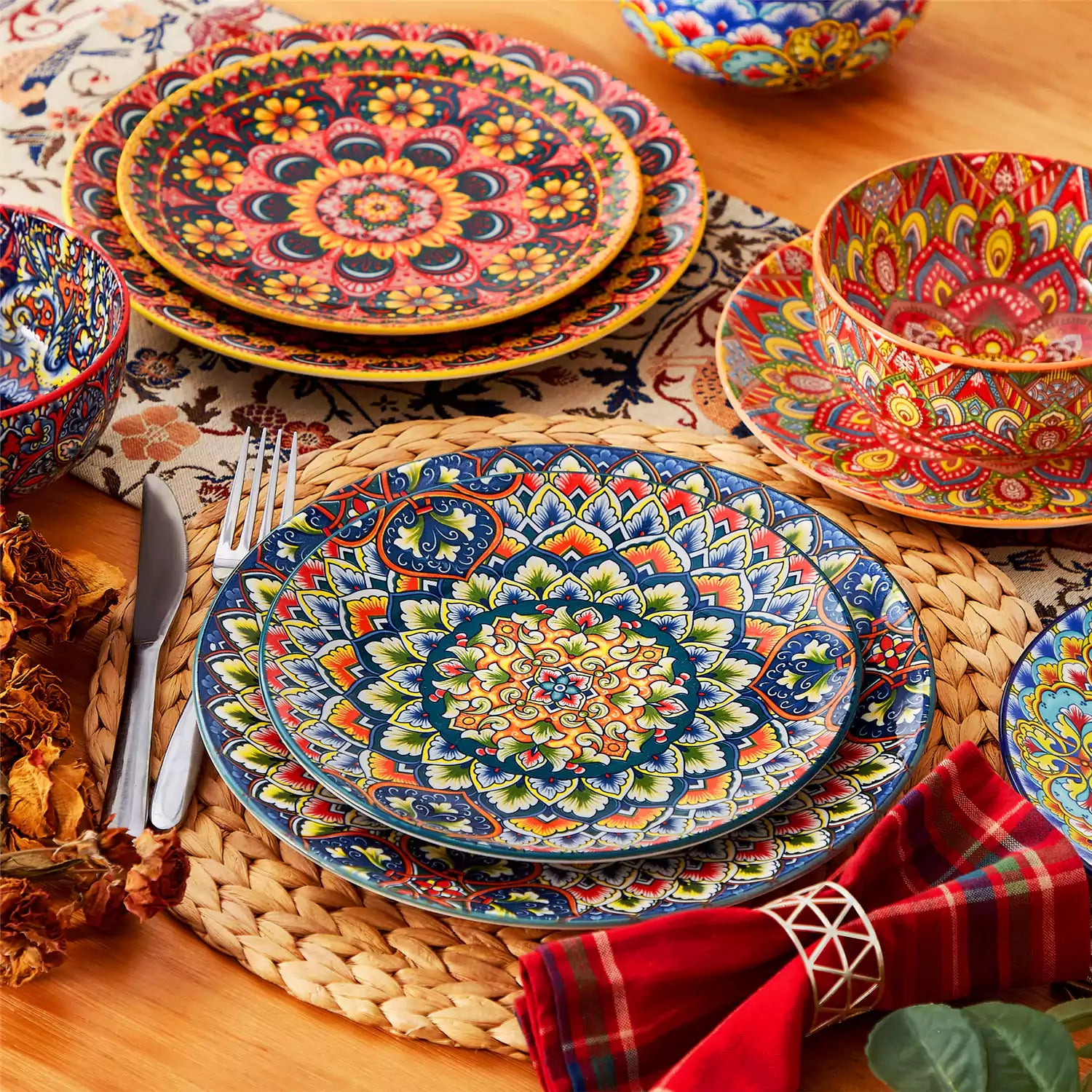 Lumi 18-piece Bohemian dinnerware set for six on a wooden table with colorful plates bowls and silverware in a playful Boho style