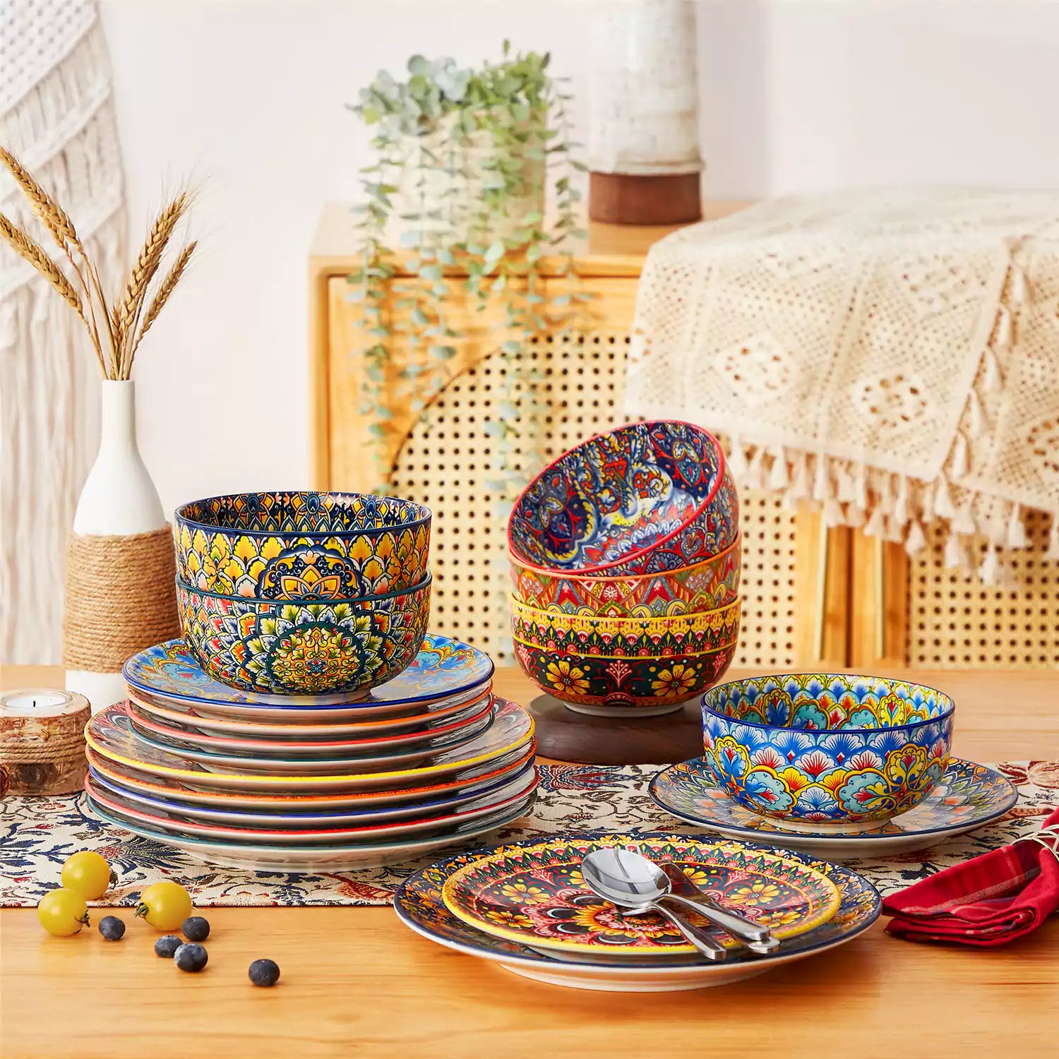 Lumi 18-piece Bohemian dinnerware set for six on a wooden table with colorful plates bowls and silverware in a playful Boho style