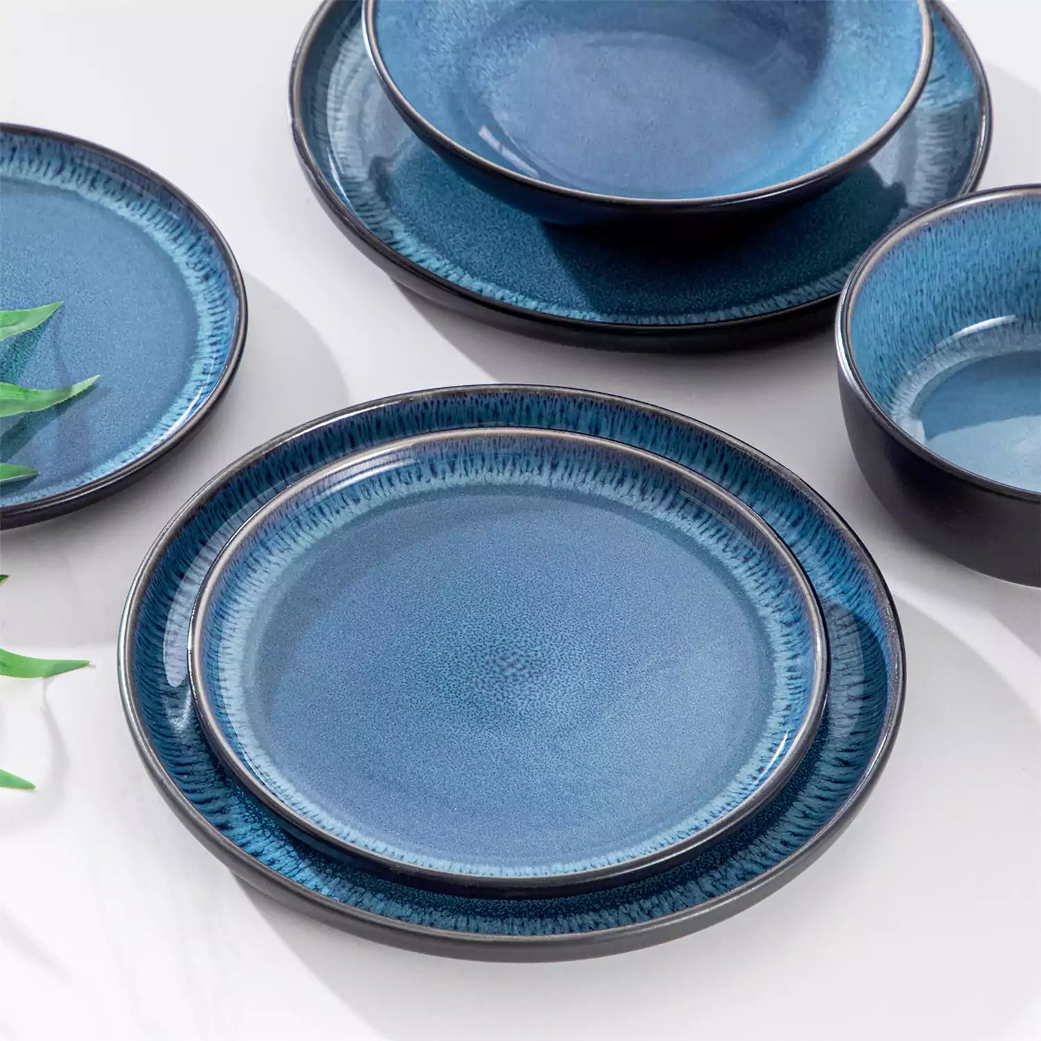 A glossy blue 24-piece stoneware dinnerware set from the Playa collection - featuring farmhouse charm with plates and bowls for 6 people-vancasso