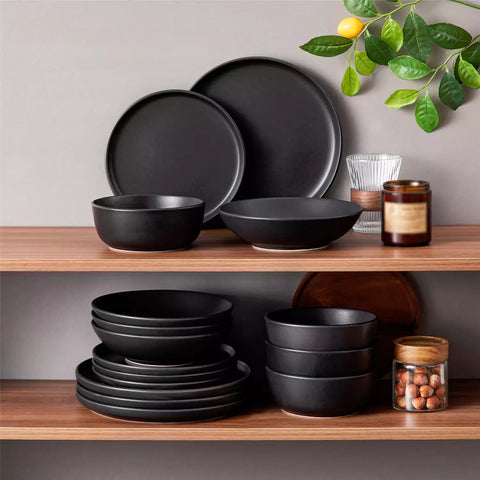 A matte black 16-piece stoneware dinnerware set from the Playa collection - offering a modern touch with plates and bowls for 4 people-vancasso.