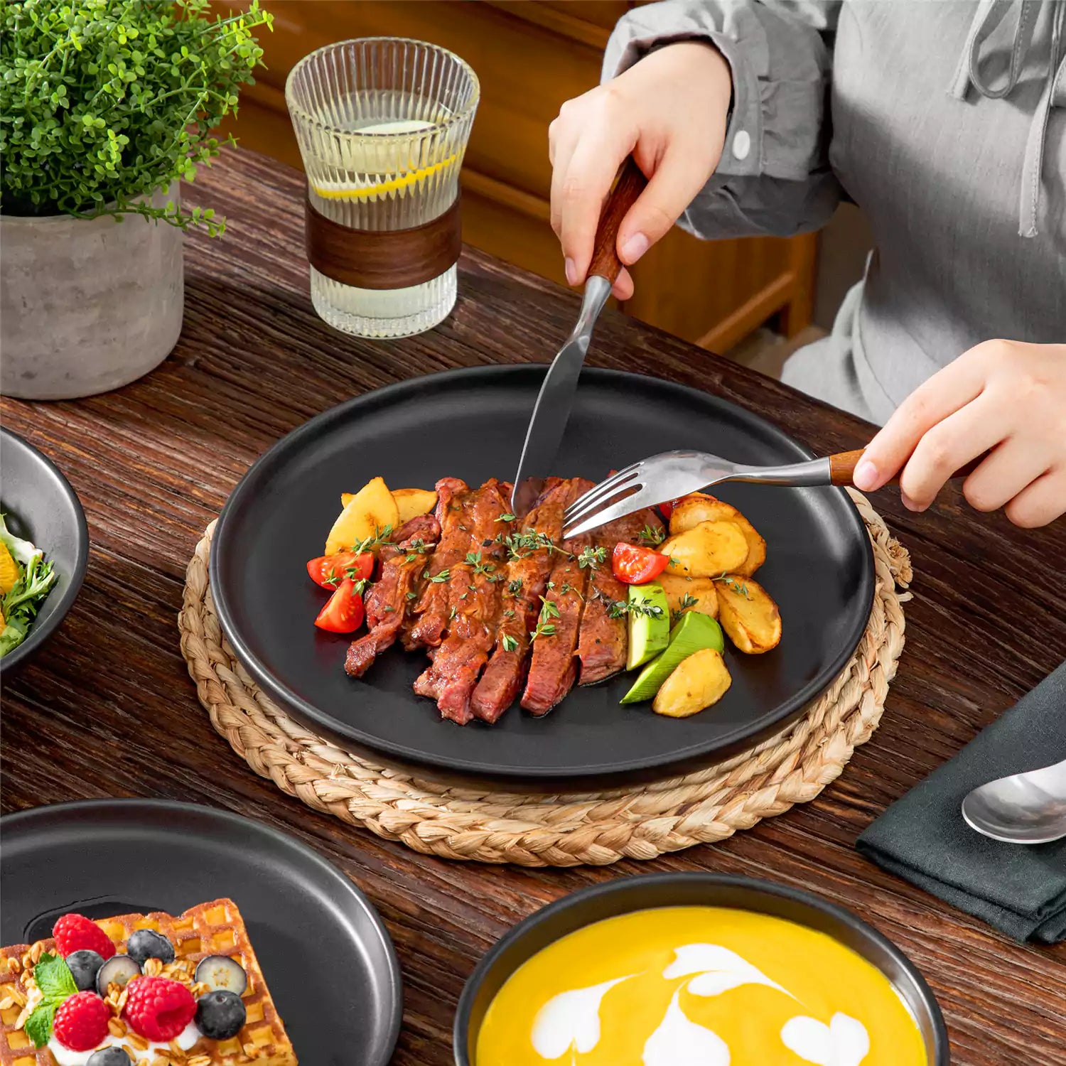 A matte black 24-piece stoneware dinnerware set from the Playa collection by vancasso - adding a modern flair with plates and bowls for 6 people