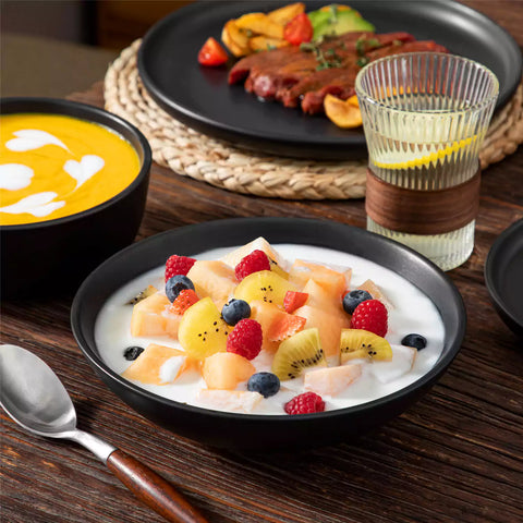 A matte black 24-piece stoneware dinnerware set from the Playa collection by vancasso - adding a modern flair with plates and bowls for 6 people