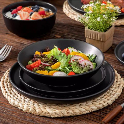 A matte black 24-piece stoneware dinnerware set from the Playa collection by vancasso - adding a modern flair with plates and bowls for 6 people