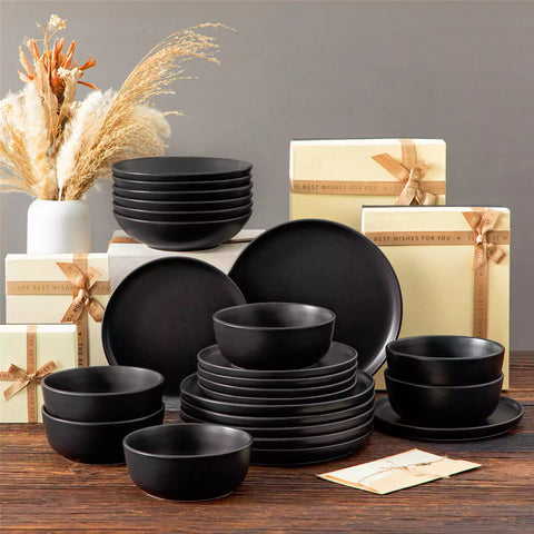 A matte black 24-piece stoneware dinnerware set from the Playa collection by vancasso - adding a modern flair with plates and bowls for 6 people