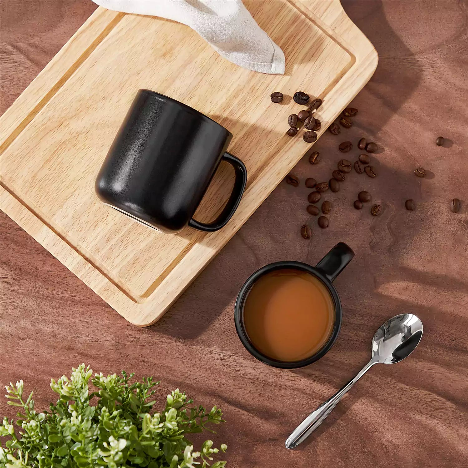 Playa 12oz stoneware mug in solid matte black on a rustic wooden surface for a moody coffee break with spoon and scattered beans