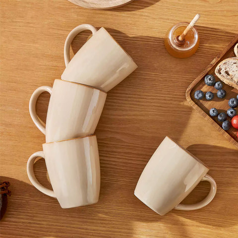 Playa 16oz stoneware mugs in brown reactive glaze on a rustic wooden surface for a cozy morning pour with coffee carafe and scattered beans