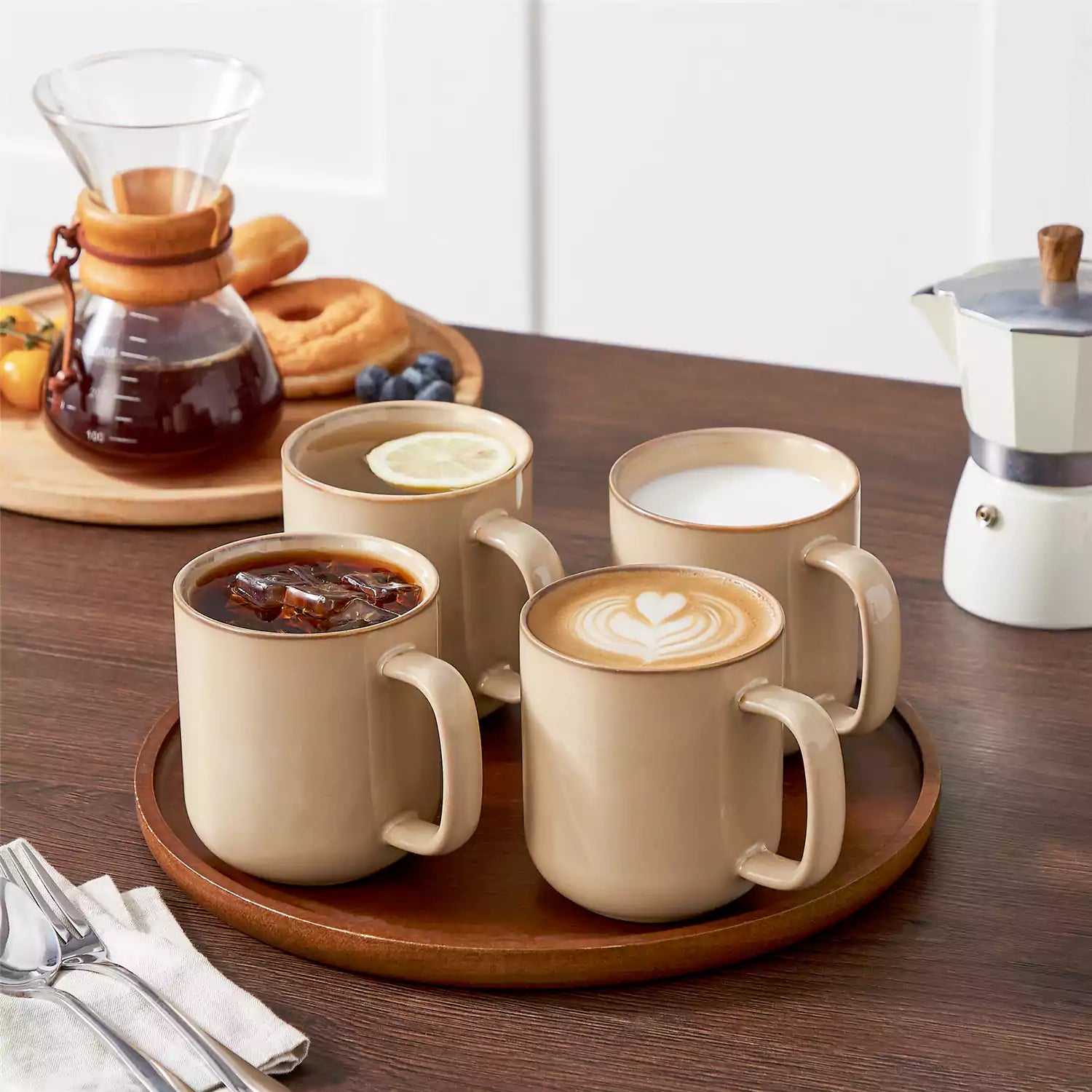 Playa 16oz stoneware mugs in brown reactive glaze on a rustic wooden café table with coffee maker and pastries