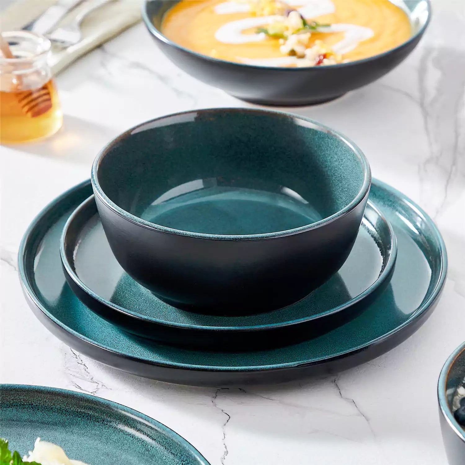 A glossy teal 24-piece stoneware dinnerware set from the Playa collection - featuring farmhouse charm with plates and bowls for 6 people-vancasso