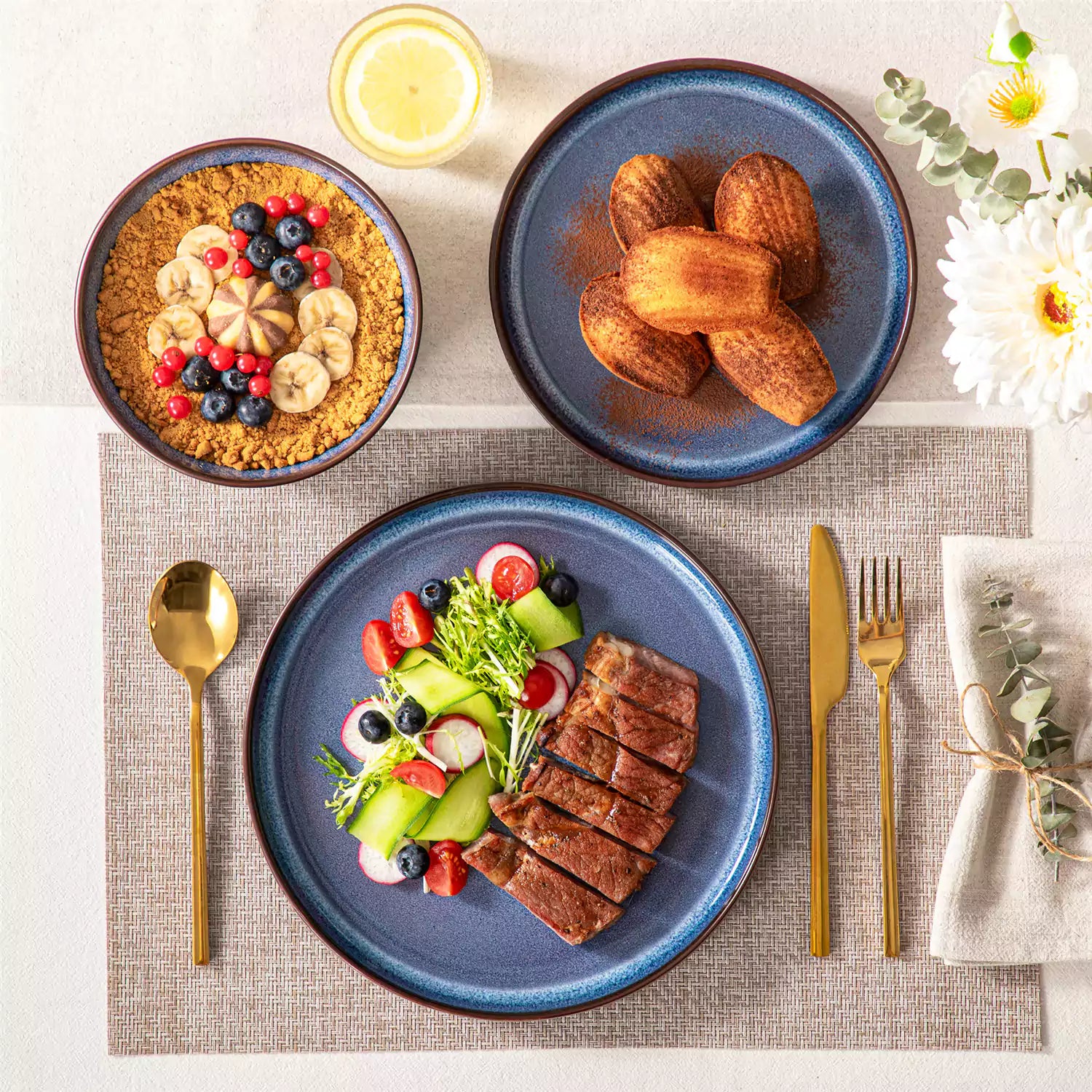 Sata blue stoneware 12 piece dinnerware set with dinner plates salad plates and cereal bowls styled with gold cutlery on textured surface farmhouse reactive glaze lipped edge service for 4