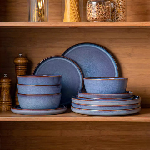 Sata blue stoneware 12 piece dinnerware set with dinner plates salad plates and cereal bowls styled with gold cutlery on textured surface farmhouse reactive glaze lipped edge service for 4
