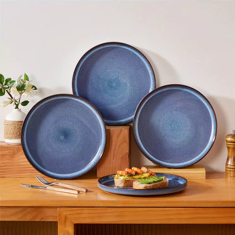 Sata blue stoneware dinner plate set of 4 styled with lamb chops and vegetables on a dinner table farmhouse lipped edge reactive glaze one of a kind finish