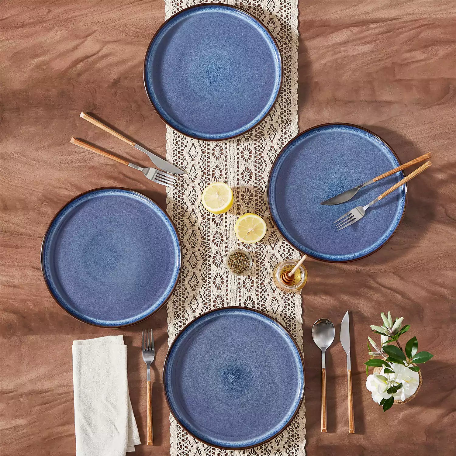 Sata blue stoneware dinner plate set of 4 styled with lamb chops and vegetables on a dinner table farmhouse lipped edge reactive glaze one of a kind finish