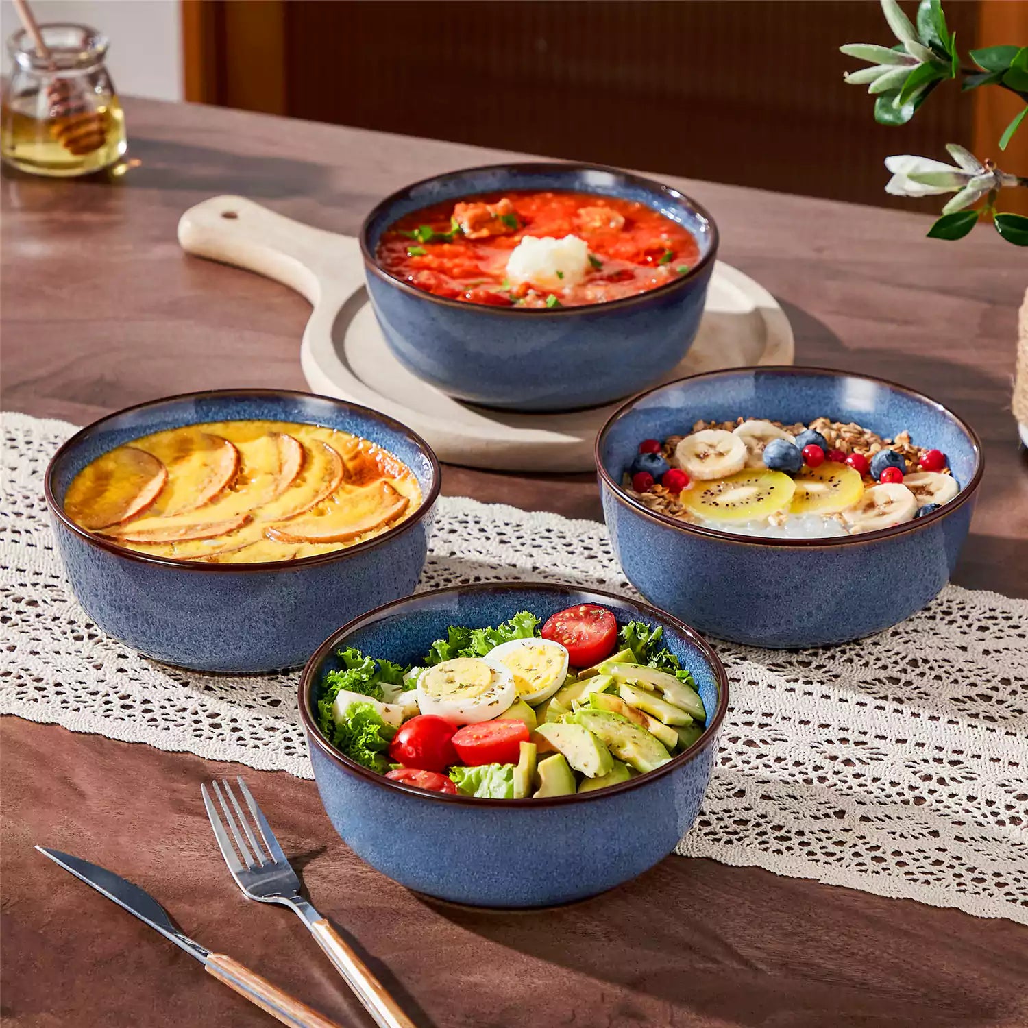 Sata blue stoneware cereal bowls set of 4 with assorted meals styled on a wooden table with lace tablecloth farmhouse reactive glaze lipped edge artisan finish