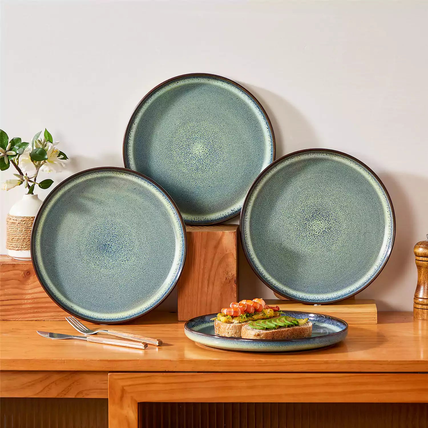 Sata green stoneware dinner plate set of 4 styled with lamb chops and vegetables on a dinner table farmhouse lipped edge reactive glaze one of a kind finish