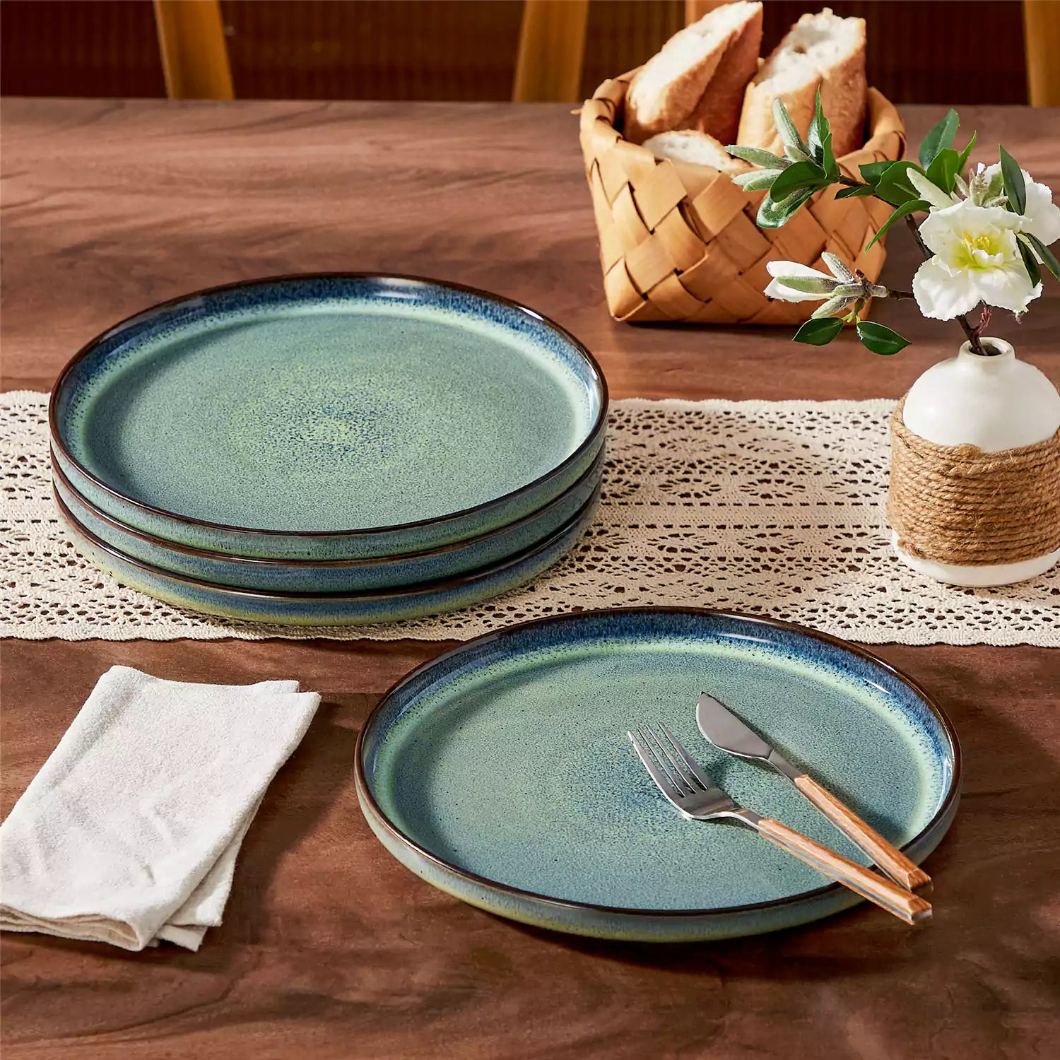 Sata green stoneware dinner plate set of 4 styled with lamb chops and vegetables on a dinner table farmhouse lipped edge reactive glaze one of a kind finish