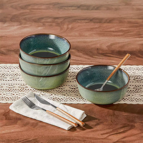 Sata green stoneware cereal bowls set of 4 with assorted meals styled on a wooden table with lace tablecloth farmhouse reactive glaze lipped edge artisan finish