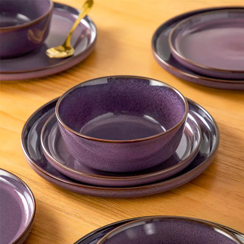 Sata purple stoneware 18 piece dinnerware set with dinner plates salad plates and cereal bowls styled on a wooden table with diverse meal setup farmhouse reactive glaze lipped edge service for 6