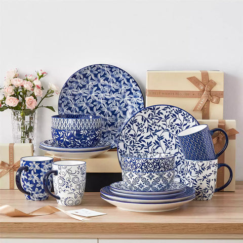 Selene 16-piece porcelain set in indigo patterns - showcasing plates - bowls - and mugs beautifully styled with vibrant meals on a rustic wooden table