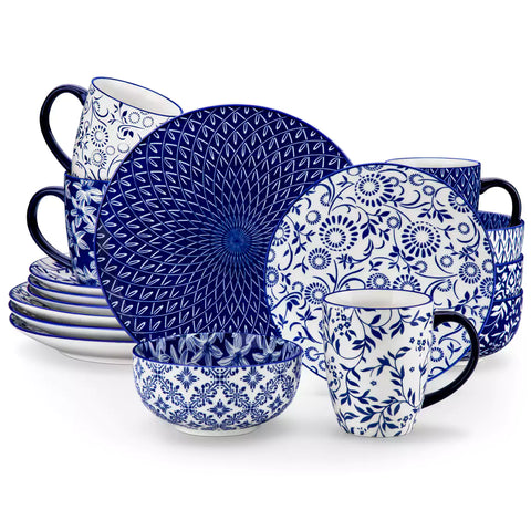 Selene 16-piece porcelain set in indigo patterns - showcasing plates - bowls - and mugs beautifully styled with vibrant meals on a rustic wooden table