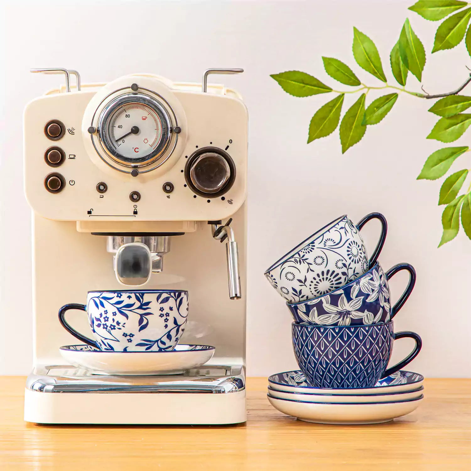 Set of 4 Selene indigo floral porcelain cups and saucers on a wooden table with coffee and pastries featuring blue and white Japanese style mix and match patterns